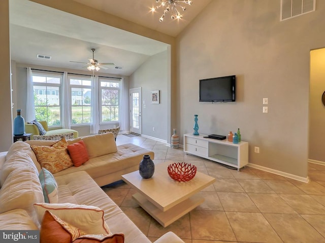 living area with light tile patterned flooring, visible vents, baseboards, and vaulted ceiling