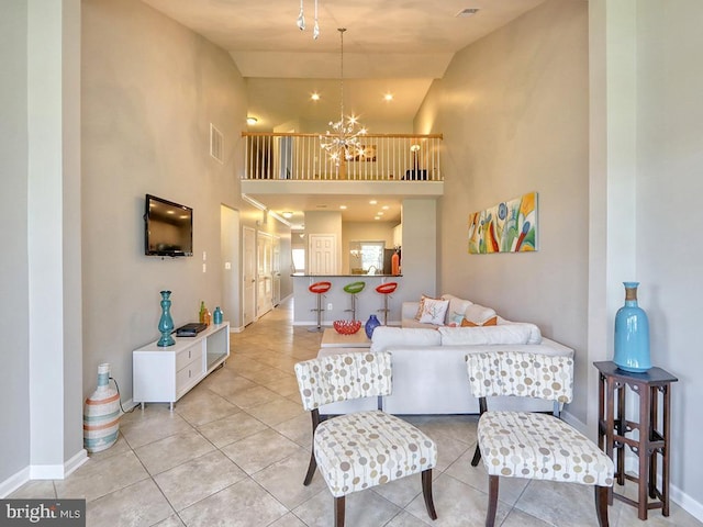 living area featuring baseboards, visible vents, a high ceiling, light tile patterned flooring, and a chandelier