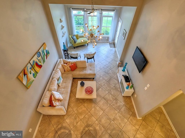 living room featuring light tile patterned floors, baseboards, and an inviting chandelier