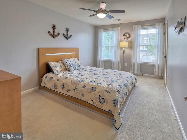 carpeted bedroom with visible vents, baseboards, and ceiling fan