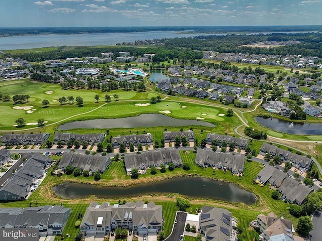 birds eye view of property with golf course view and a water view