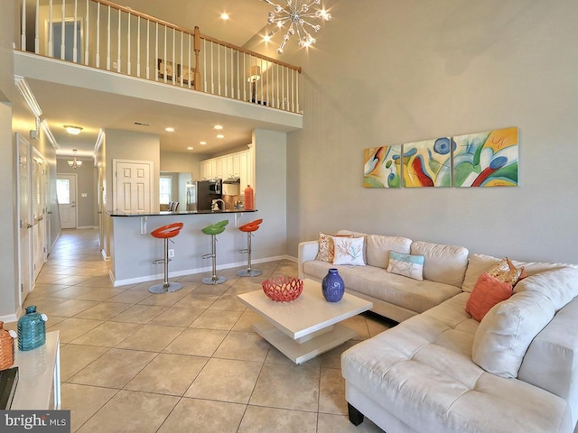 living room featuring baseboards, an inviting chandelier, a high ceiling, light tile patterned flooring, and recessed lighting