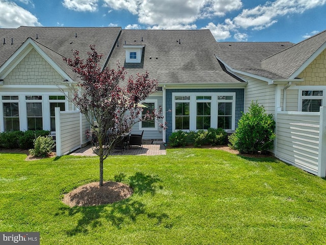 back of house featuring a yard, a patio area, fence, and a shingled roof