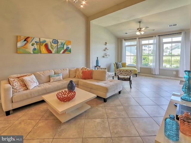 living room with light tile patterned floors, a ceiling fan, visible vents, baseboards, and vaulted ceiling