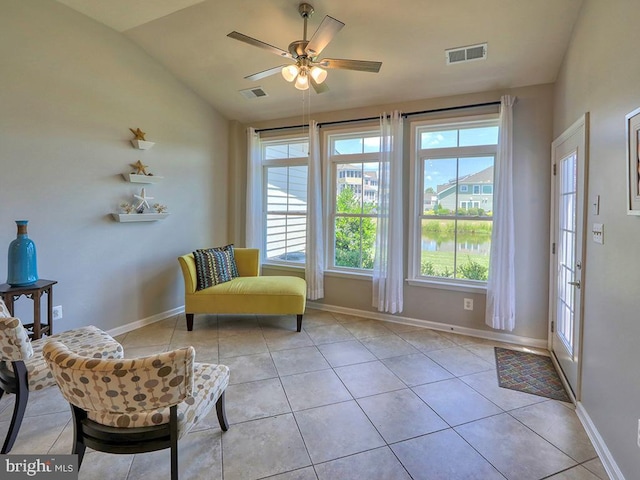 living area featuring vaulted ceiling, light tile patterned floors, baseboards, and visible vents