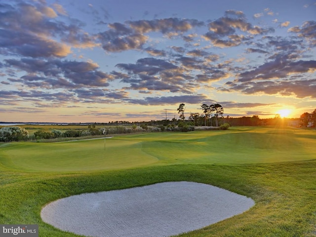 surrounding community featuring a lawn and golf course view