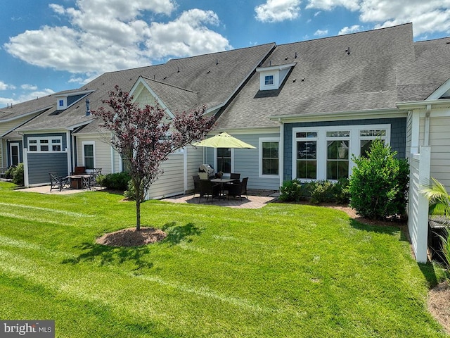 back of property featuring a patio area, a lawn, and roof with shingles