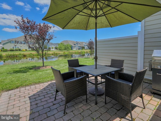 view of patio / terrace featuring a residential view, outdoor dining area, and a water view