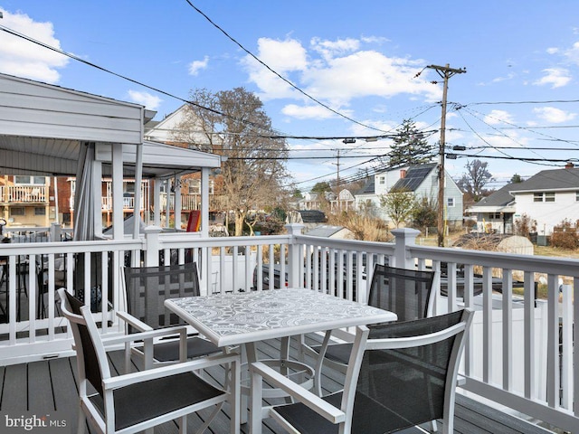 wooden terrace featuring outdoor dining space and a residential view