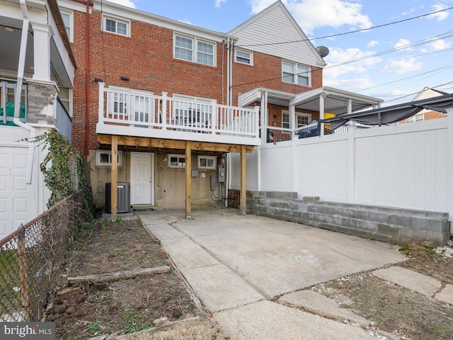 back of property featuring brick siding, a patio area, and fence