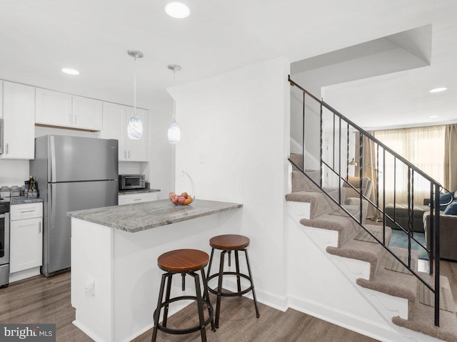 kitchen featuring dark wood finished floors, light stone counters, white cabinetry, and stainless steel appliances