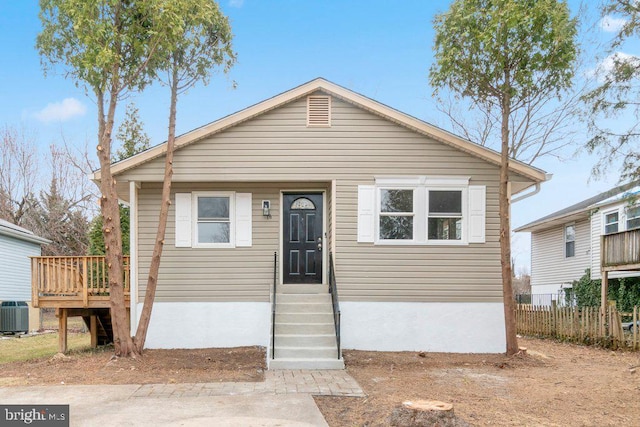 view of front of house with central air condition unit and fence