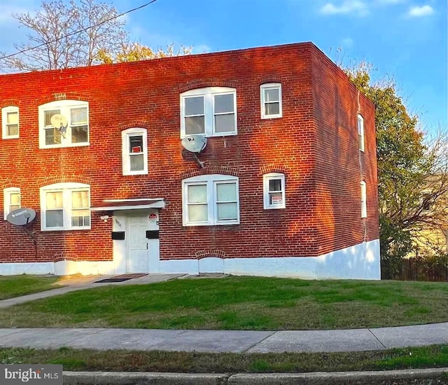 view of front facade featuring brick siding and a front yard