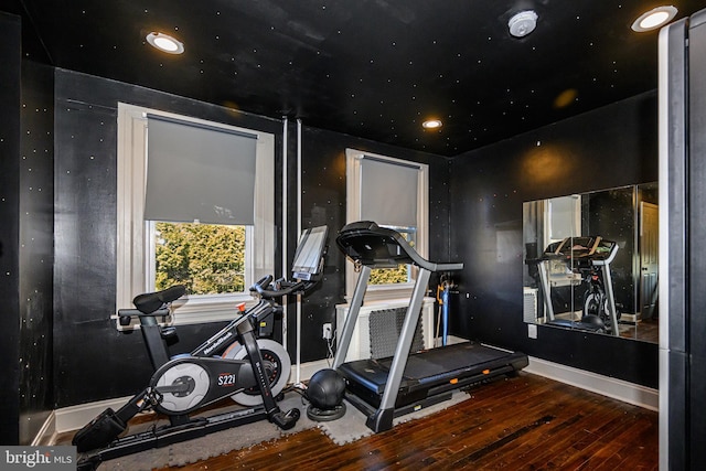 workout room featuring baseboards and wood-type flooring