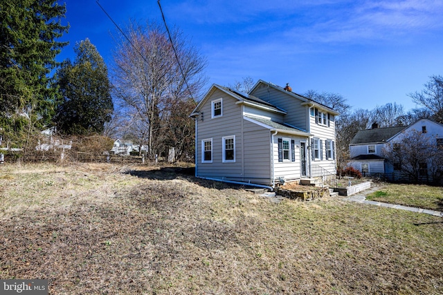 view of side of property with a lawn and a chimney