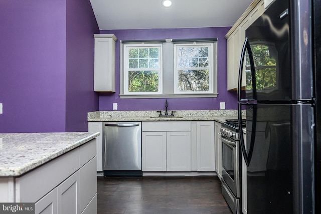 kitchen with dark wood-style floors, plenty of natural light, appliances with stainless steel finishes, and a sink