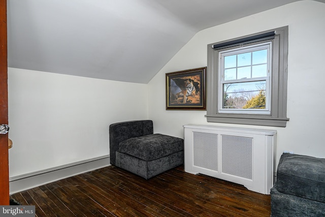 sitting room with hardwood / wood-style floors, lofted ceiling, radiator heating unit, and a baseboard heating unit