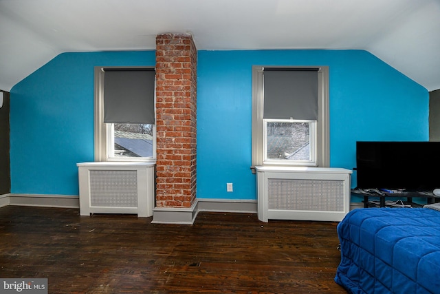 bedroom featuring baseboards, lofted ceiling, radiator heating unit, and hardwood / wood-style flooring