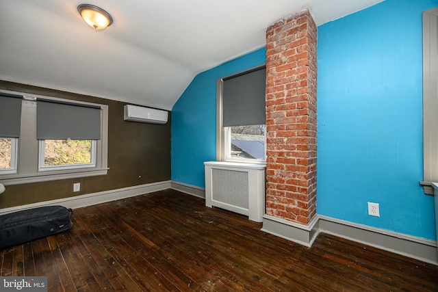 interior space with a wall unit AC, radiator, baseboards, lofted ceiling, and wood-type flooring