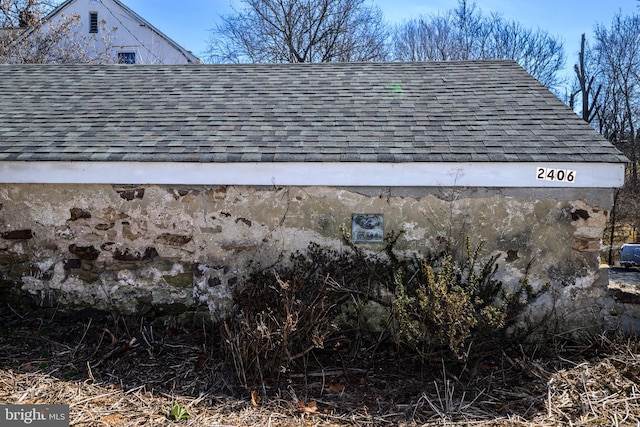 exterior details featuring roof with shingles