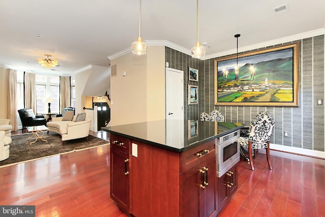 kitchen with wallpapered walls, stainless steel microwave, dark brown cabinets, and an accent wall