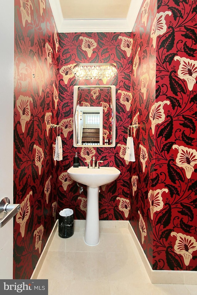 half bath featuring tile patterned flooring, crown molding, and wallpapered walls