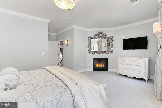 bedroom featuring visible vents, baseboards, ornamental molding, carpet flooring, and a glass covered fireplace