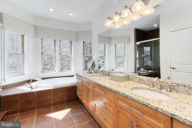 bathroom featuring tile patterned floors, a garden tub, a stall shower, and a sink