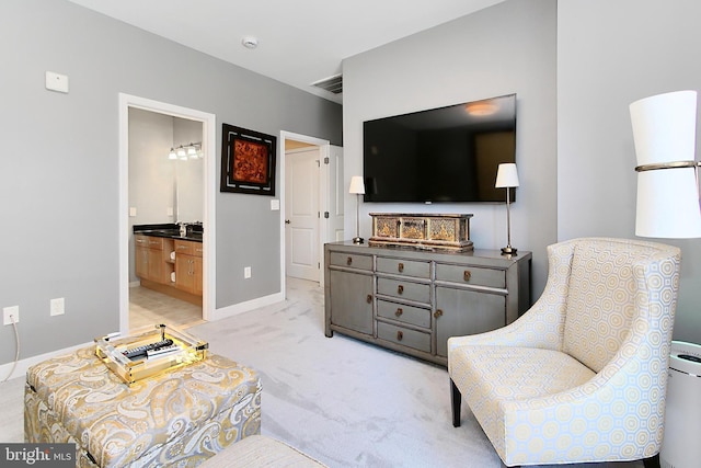 living area featuring visible vents, baseboards, and light colored carpet