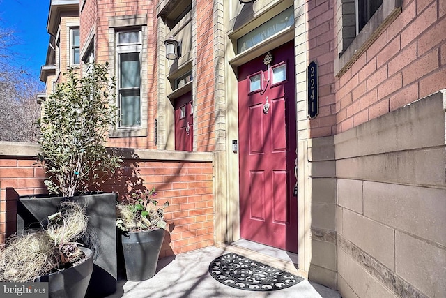 view of exterior entry featuring brick siding