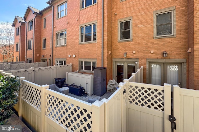 rear view of property featuring brick siding and fence