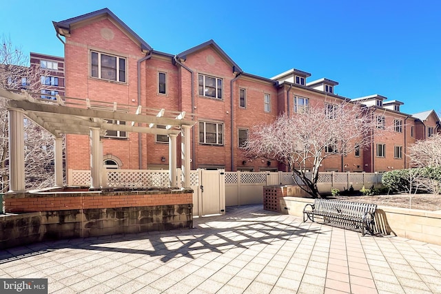 view of home's community featuring a patio area, a pergola, and fence