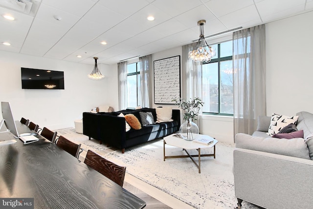 living area featuring a chandelier, a drop ceiling, recessed lighting, and visible vents