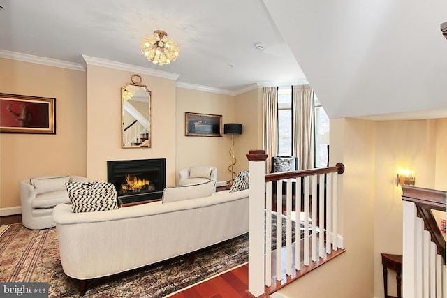 living room with a glass covered fireplace, crown molding, and wood finished floors