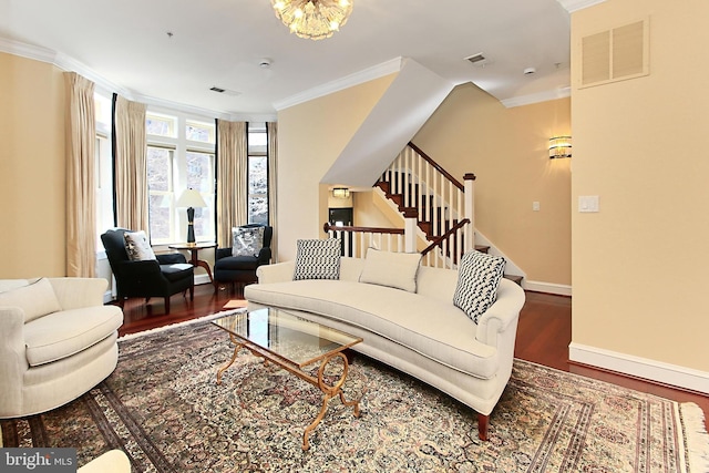 living room with visible vents, ornamental molding, wood finished floors, stairway, and baseboards