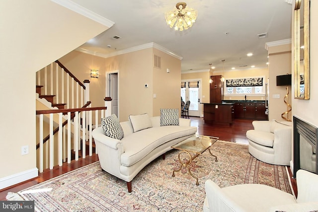 living room featuring visible vents, stairway, wood finished floors, and ornamental molding