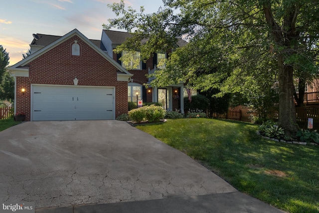 view of front facade with brick siding, fence, concrete driveway, a lawn, and an attached garage