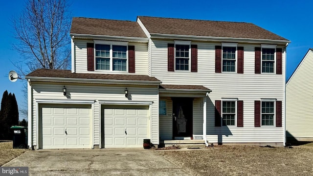 view of front of property featuring concrete driveway, a garage, and roof with shingles