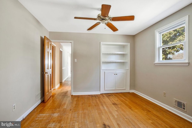 unfurnished bedroom with visible vents, baseboards, light wood-style floors, and a ceiling fan