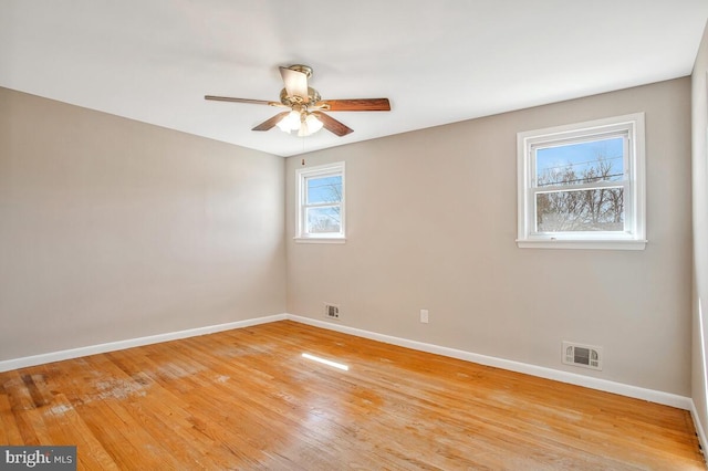 empty room with visible vents, baseboards, light wood-style floors, and ceiling fan