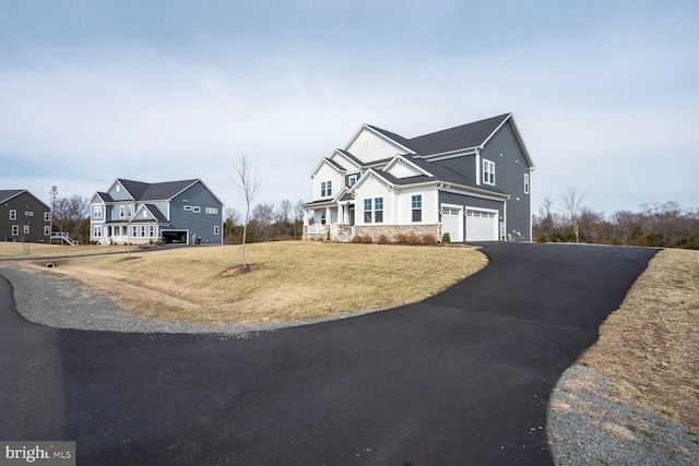 view of front of property with stone siding, driveway, a front yard, and an attached garage