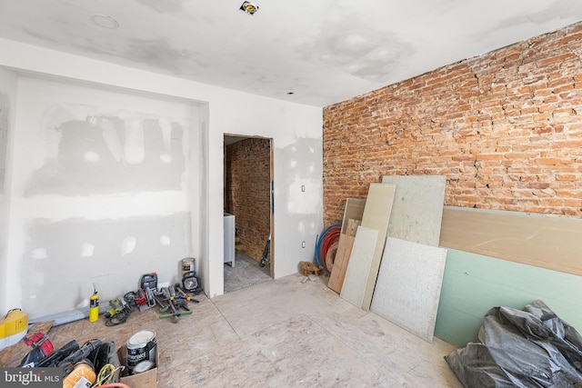 empty room featuring brick wall