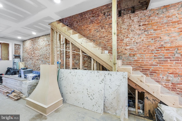 interior space featuring brick wall and concrete floors