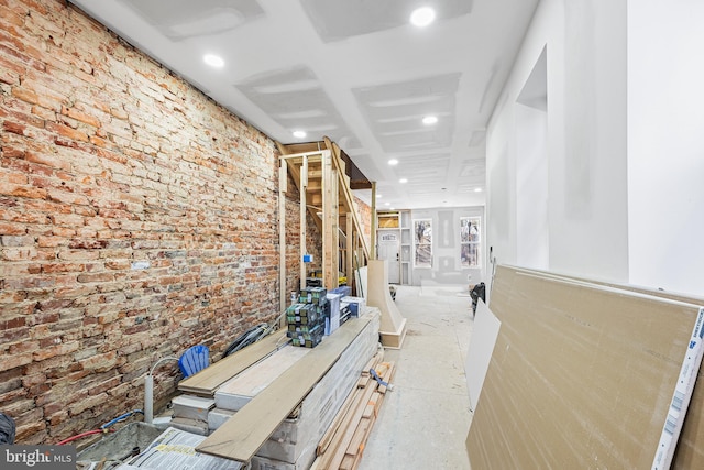 corridor featuring recessed lighting and brick wall