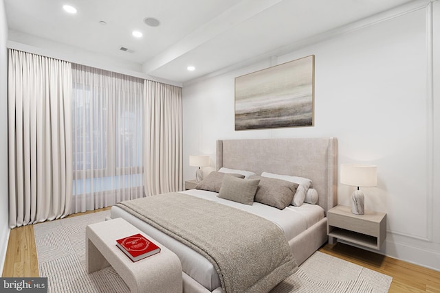 bedroom with recessed lighting, visible vents, baseboards, and wood finished floors