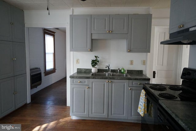 kitchen with heating unit, black electric range oven, dark countertops, and a sink