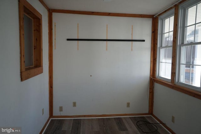 spare room featuring baseboards and wood finished floors