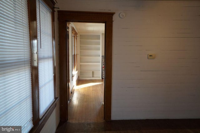 hall with hardwood / wood-style flooring and wood walls