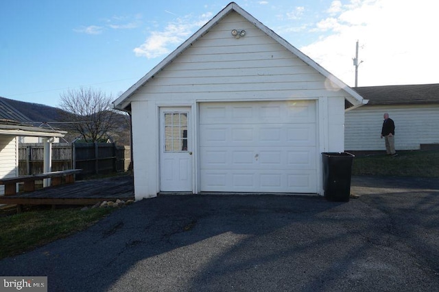 garage with fence and driveway