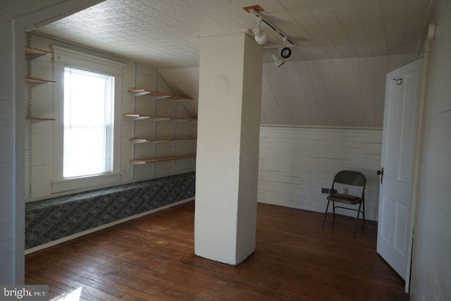 bonus room featuring hardwood / wood-style flooring, wooden walls, and lofted ceiling